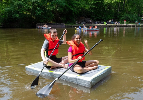 two students in cardboard boat